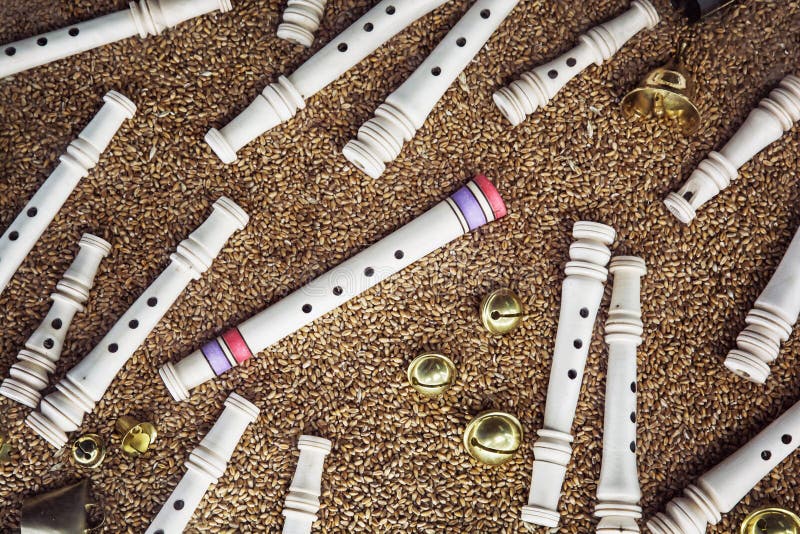Wooden whistles, brass bells and gingle bells on the grain background