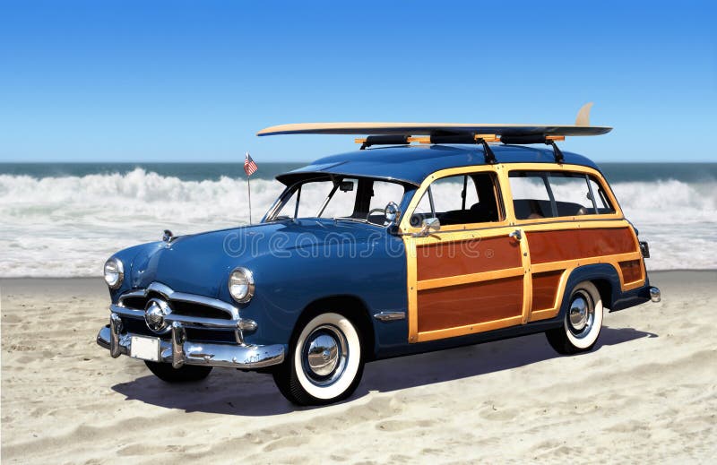 Woodie auto na pláži s surf a modré nebe.