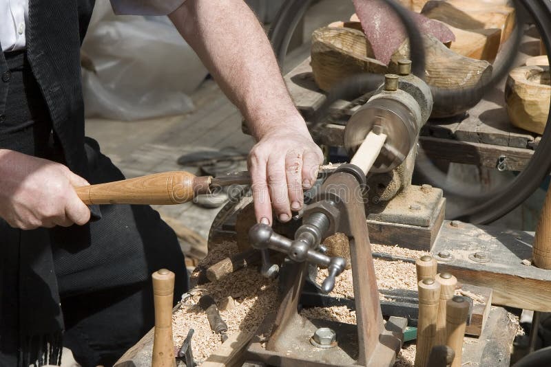 A craftsman turning wood on a lathe. A craftsman turning wood on a lathe