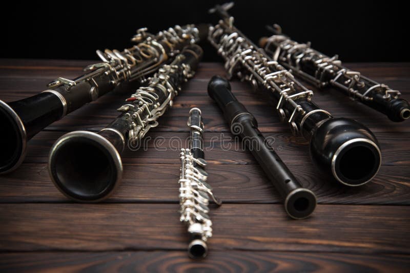 Woodwind instruments lie on a wooden surface. Side view