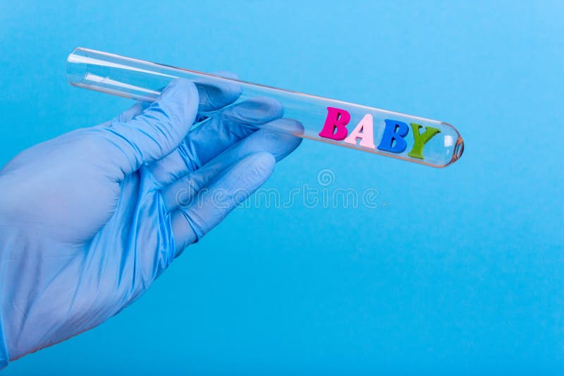 Word baby in test-tube holding a gloved hand