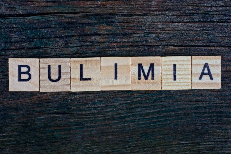 Word bulimia made from wooden gray letters lies on a gray background