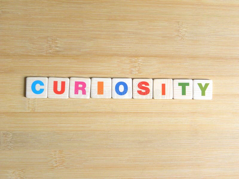 Word Curiosity on wood background