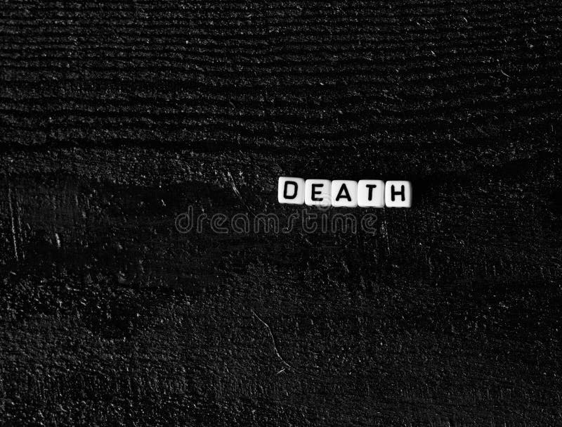 The word `death` made of cubes on a black wooden background. black background stock photography