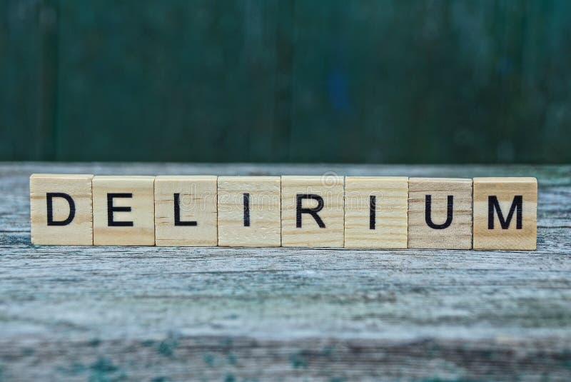 Word delirium made of wooden letters on a gray table on a green background