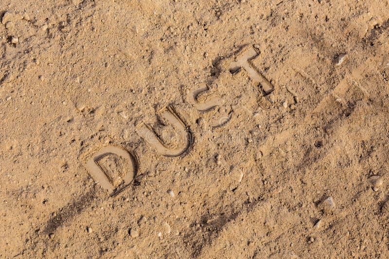 The Word Dust on Dusty Road Surface in Flat Lay Perspective Stock Photo
