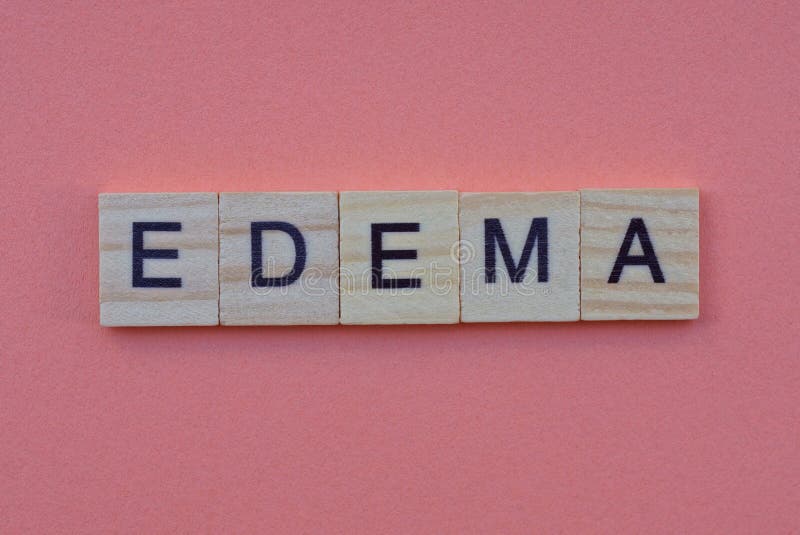 Word edema from small gray wooden letters lies on a red background