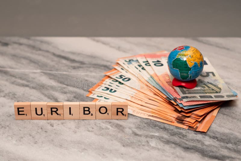 Word EURIBOR Is Written In Wooden Letters, Near Stack of Money Of 5, 10, 20 and 50 Euro Banknotes and Globe. High quality photo