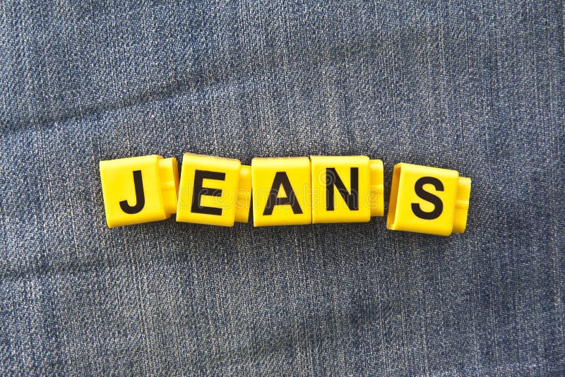 Word Jeans Made of Wooden Letters on Blue Trouser Fabric Stock Photo