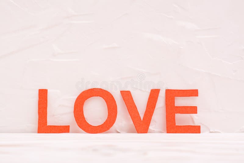 The Word `love` from Cut Out Red Cardboard Letters on a White