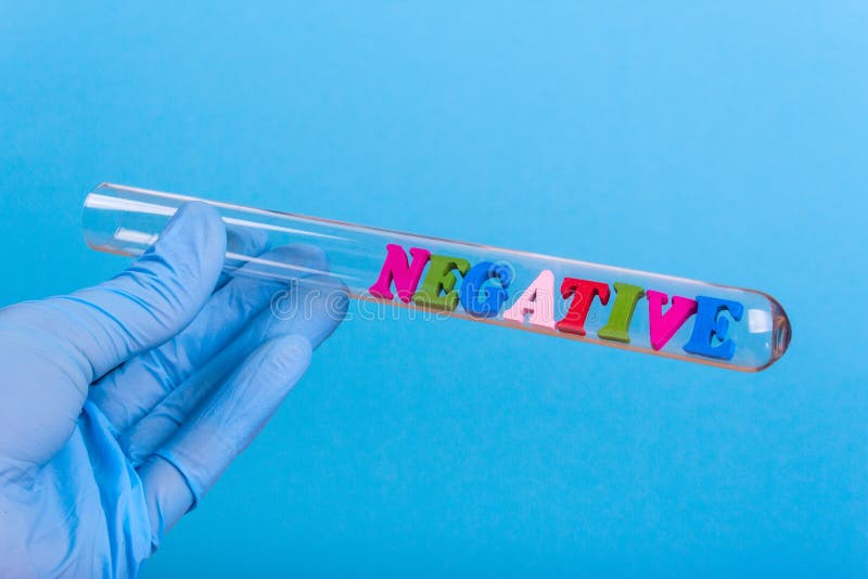 Word negative in test-tube holding a gloved hand