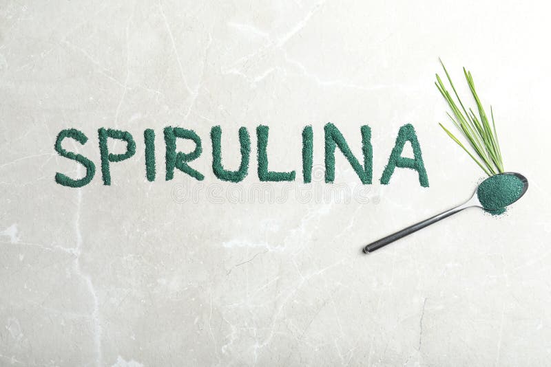 Word SPIRULINA made of algae powder, spoon and grass on light background