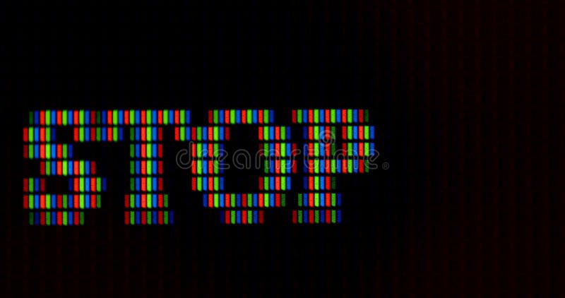 Word stop is written pixel letters monitor. RGB font rendering. Dark background