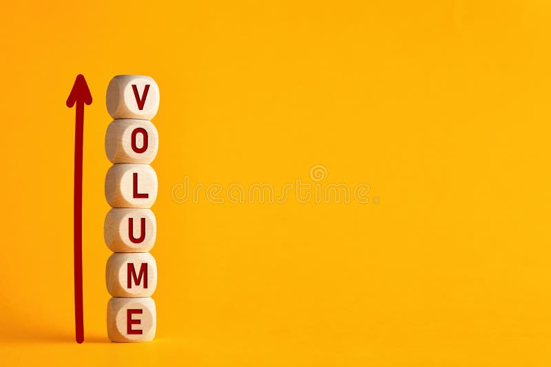 The word volume on stacked wooden cubes with arrow. Increasing music volume or production quantity or capacity in business