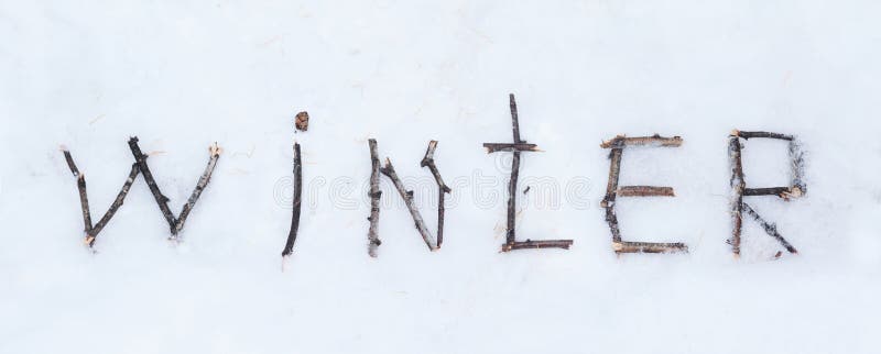The word winter written with broken wooden sticks on snow backgr