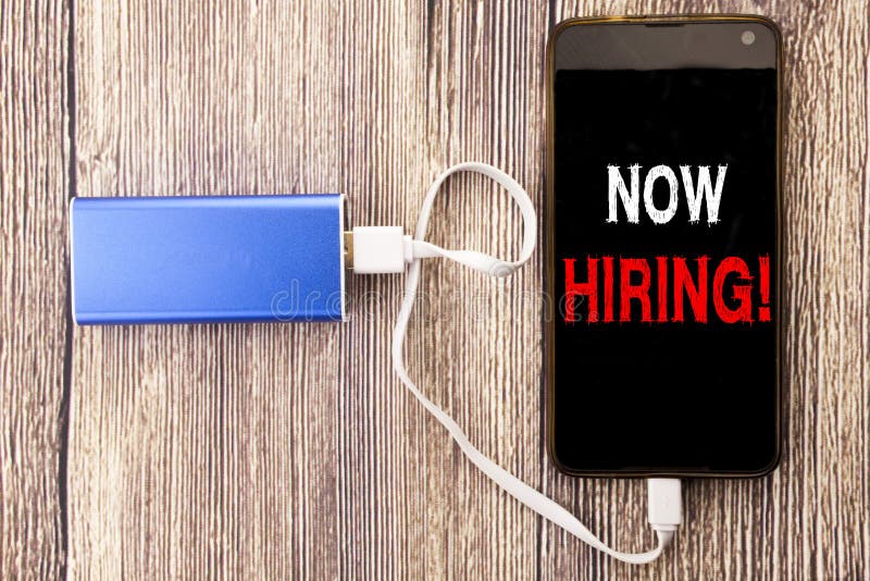 Word, writing Now Hiring. Business concept for Hire Recruitment written on mobile cell phone mobile and power-bank charger on old