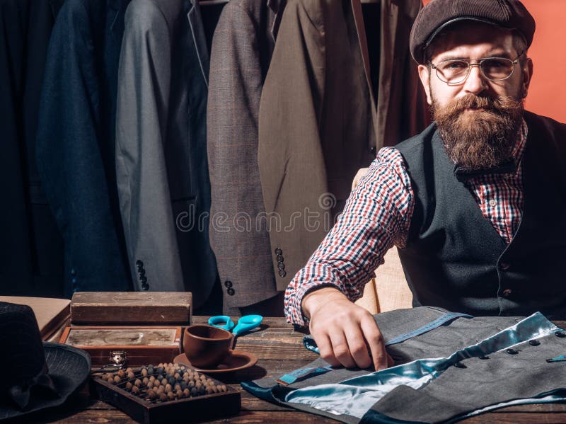 Wordende ideeën kleding Zijn ontwerpen zijn veel gevraagd Het gebaarde naaiende jasje van de mensenkleermaker kostuumopslag bedri stock afbeeldingen Wordende ideeën kleding Zijn ontwerpen zijn veel gevraagd Het gebaarde naaiende jasje van de mensenkleermaker kostuumopslag bedri stock afbeeldingen