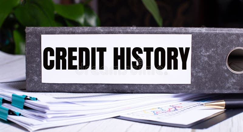 The words CREDIT HISTORY is written on a gray file folder next to documents. Business concept.