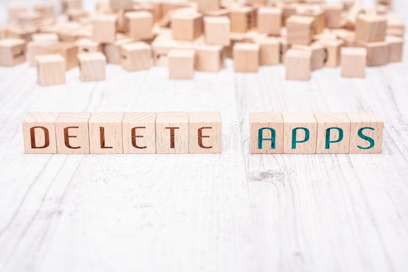 The Words Delete Apps Formed By Wooden Blocks On A White Table