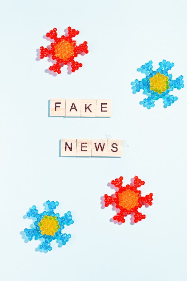 Words fake news made of wooden blocks with coronavirus model on blue background, flat lay, top view. Fake news about pandemic stock photos Words fake news made of wooden blocks with coronavirus model on blue background, flat lay, top view. Fake news about pandemic stock photos