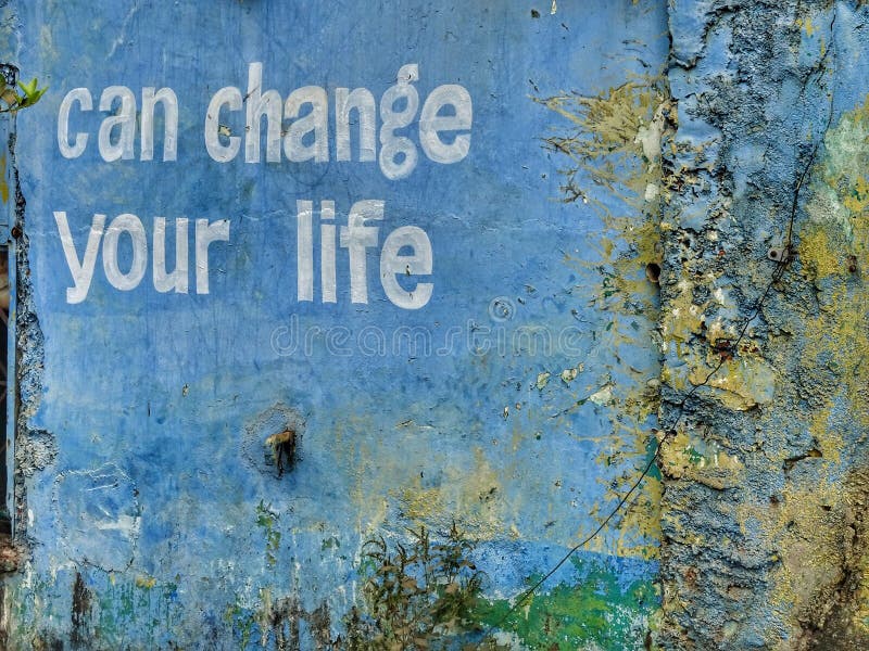 A small positive thinking can change your life written on a blue wall. A small positive thinking can change your life written on a blue wall