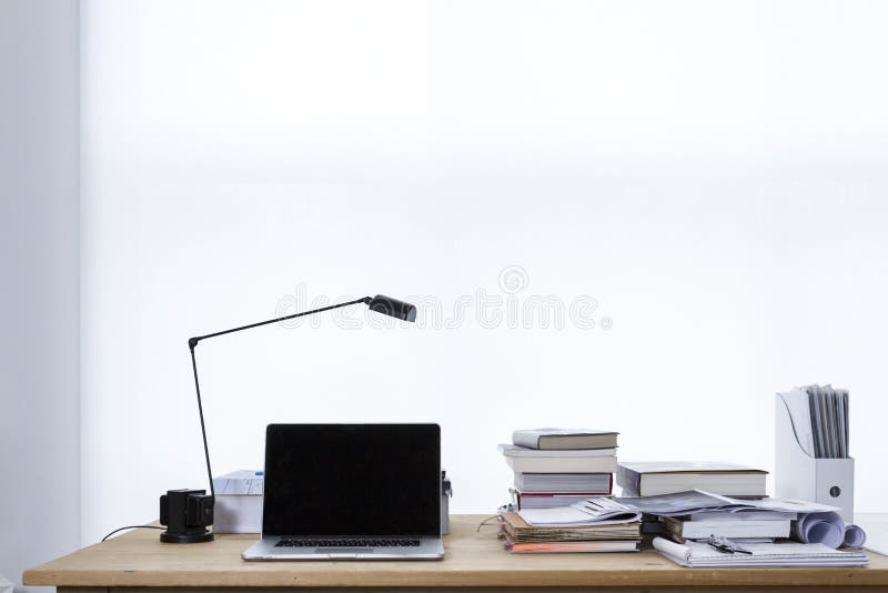 Work Desk With A Lamp, A Laptop, Books, And Papers On It With A White Background