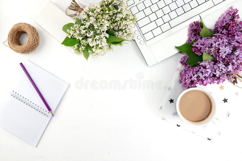 Work desk of a modern woman, home office. Computer, spring flowers and a cup of coffee on a light table. Minimal business concept