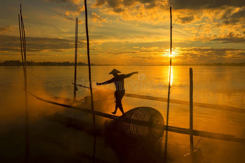 The work of fishermen on the Mekong River raft during the sunrise is a hustling and indigenous way of life in Nong Khai province, opposite to Vientiane Laos. The work of fishermen on the Mekong River raft during the sunrise is a hustling and indigenous way of life in Nong Khai province, opposite to Vientiane Laos.