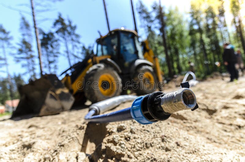 The work of a large two-wheeled tractor when laying water supply for water supply of private homes. royalty free stock images The work of a large two-wheeled tractor when laying water supply for water supply of private homes. royalty free stock images
