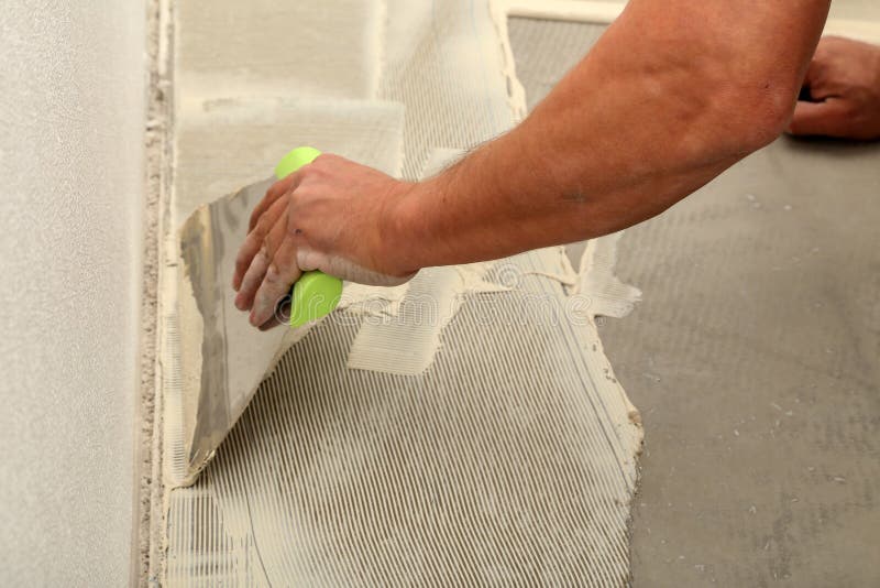 Work on Laying Flooring. Worker Installing New Vinyl Tile Floor. Stock