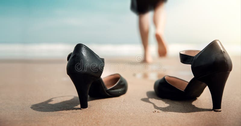 Work Life Balance Concept. Business Woman take off her Working Shoes and leave it on the Sand Beach for Walk into the Sea on Sunny