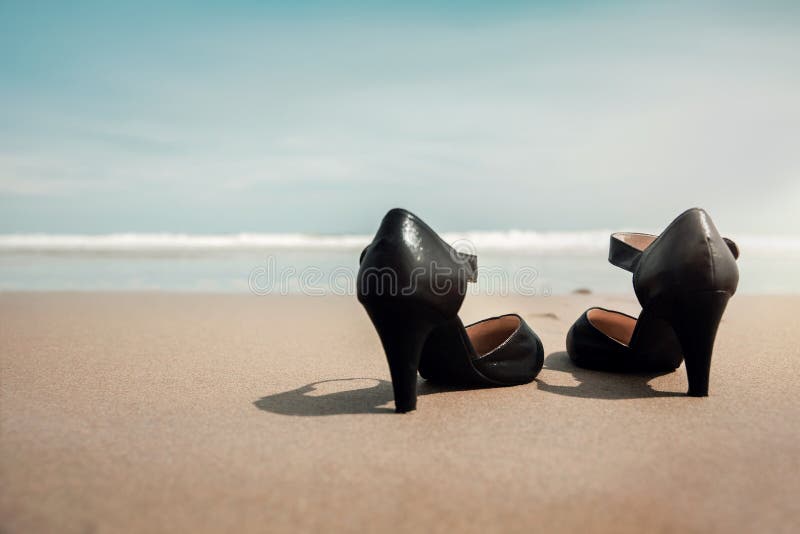 Work Life Balance Concept. Business Woman take off Working Shoes and leave it on the Sand Beach for Walk into the Sea. Quit a Job