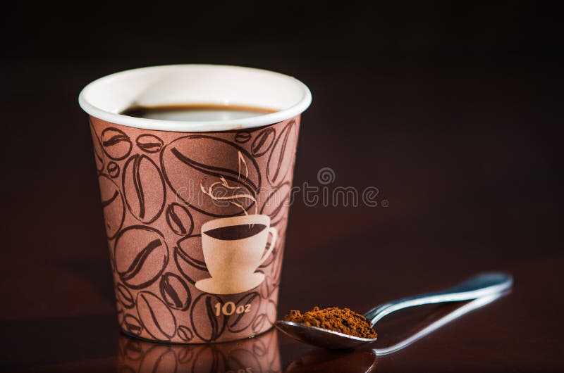 Styrofoam coffee cup with black coffee and tea spoon with powder. Styrofoam coffee cup with black coffee and tea spoon with powder