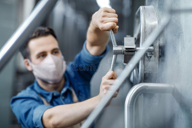 Work in plant of brewery observing process of brewing and fermentation, production of beer stock photography
