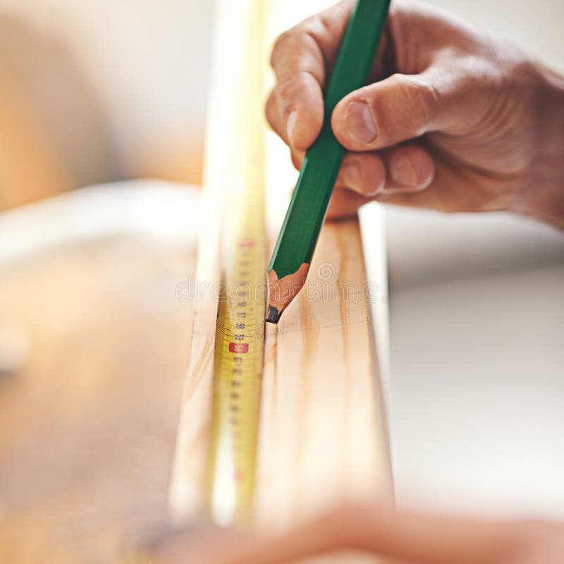 This work takes precision. a carpenter making measurements on a plank of wood. royalty free stock photo