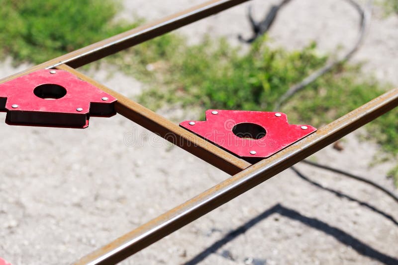 Welder Welding Angle Iron with Stick Electrode with Red and Blue