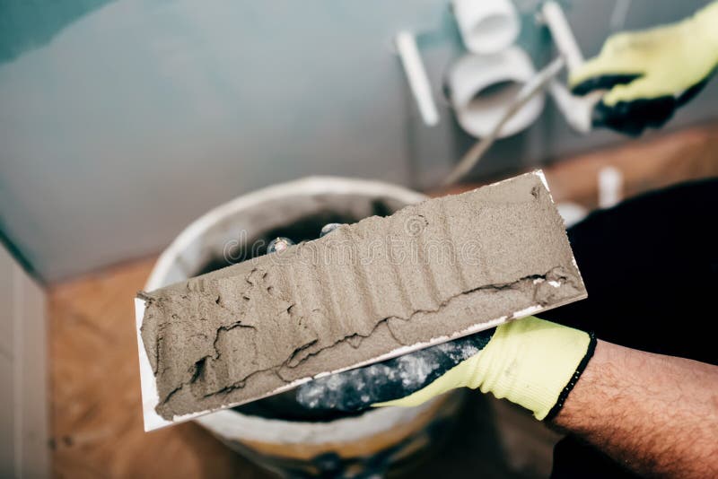 Construction worker applying mortar on ceramic tiles and working on rebuilding a bathroom. Bricklayer tiler stock images, royalty-free photos and pictures
