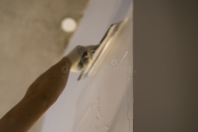 Worker Applying Putty On The Wall With Putty Knife Stock Photo