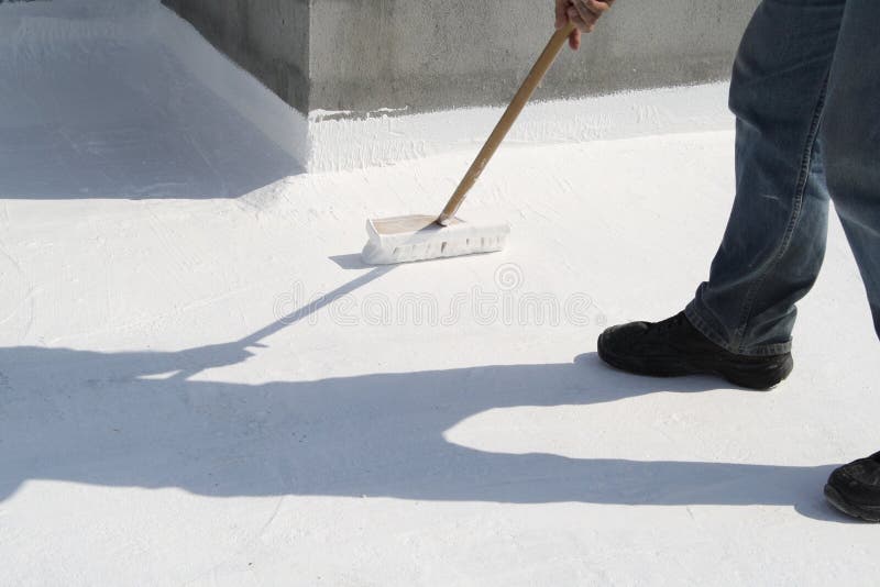 Worker applying white roof coating royalty free stock photos