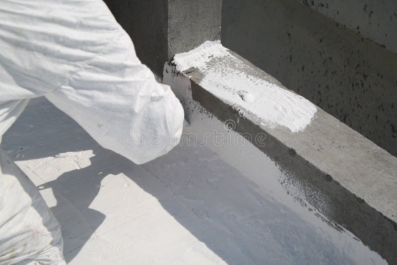 Worker applying white roof coating stock photos
