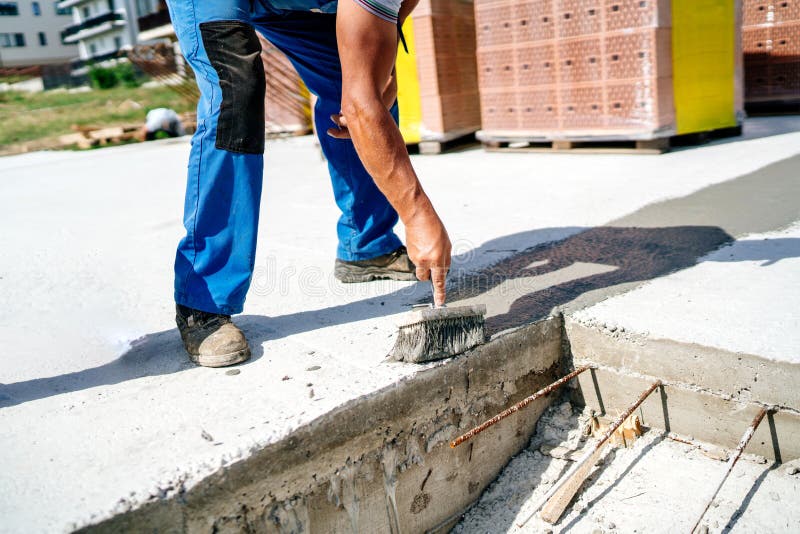 Worker applying waterproofing sealant at construction site stock photos