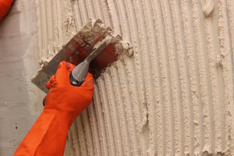 Worker applying white thinset mortar stock photo