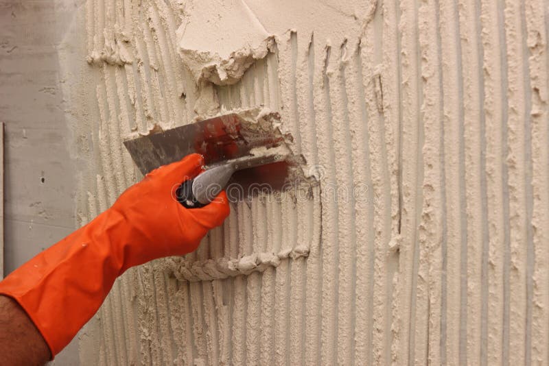 Worker applying white thinset mortar royalty free stock photography