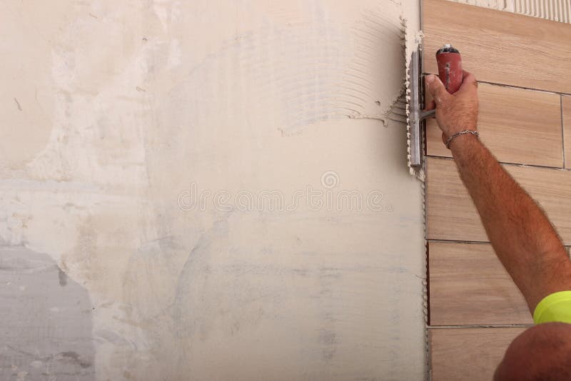 Worker applying white thinset mortar stock photography