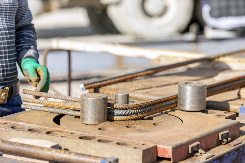 The Worker is Bending Rebars with Rebar Bending Machine in the Site