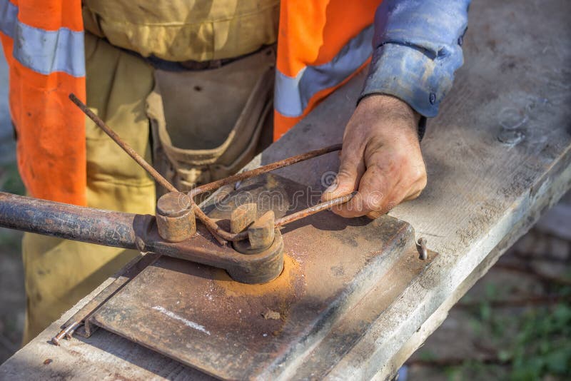 Worker bending spacers for the rebars in a concrete post 3 stock image