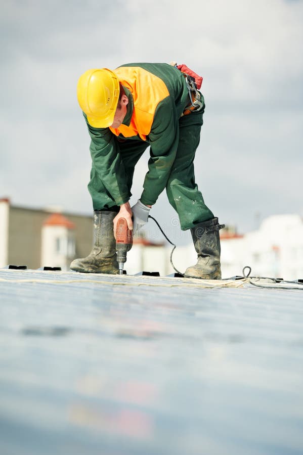 Worker builder roofer at metal profile work stock images