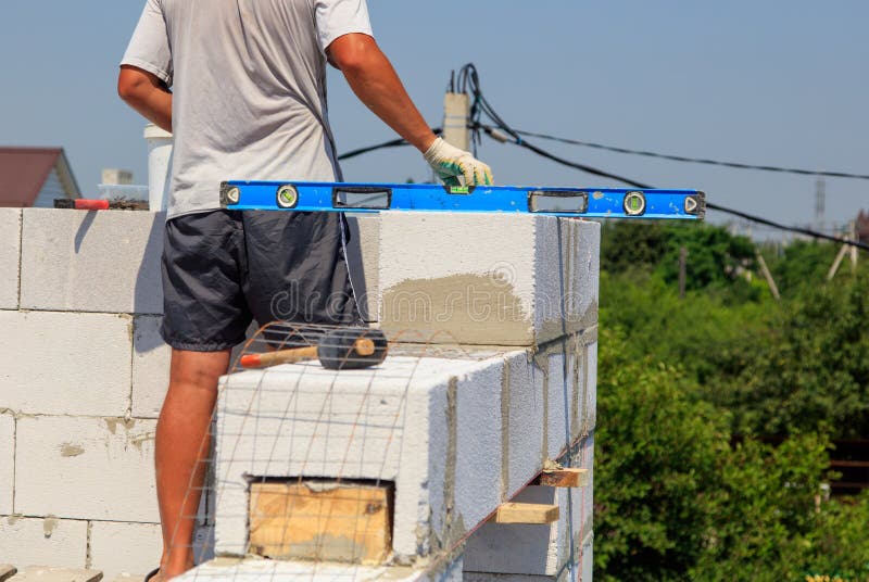 A Worker Builds the Walls of a House from Aerated Concrete Bricks Stock