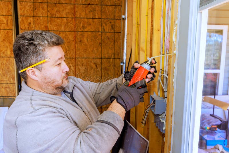 Worker handles electrical wiring at a construction site in a residential building during daylight hours royalty free stock photo