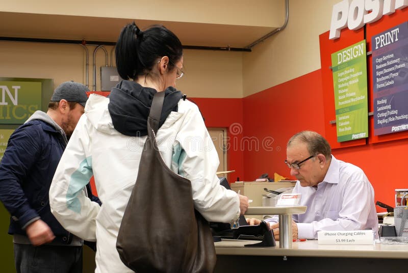 Worker Checking Parcel for Customer at Post Office Editorial Stock